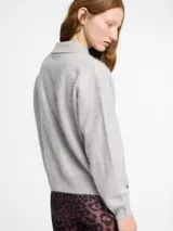 Sweater de punto de cachemira color turquesa con cuello polo y cierre frontal de tres botones. Presenta una textura suave tipo pelo, manga larga y terminaciones acanaladas en puños y ruedo.