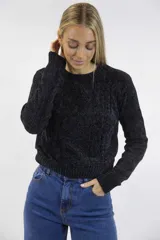 Buzo tejido de chenille color negro, de textura suave, con cuello redondo, mangas largas, diseño de tramas en rombos y terminaciones acanaladas.