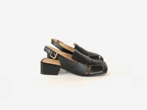 Sandalias de cuero negro con tiras anchas entrecruzadas, punta cuadrada, talón abierto con pulsera ajustable y hebilla metálica, y taco ancho medio.