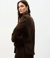 Blazer oversized estructurado marrón de corte cruzado con solapa amplia, bolsillos integrados y cuatro botones frontales.