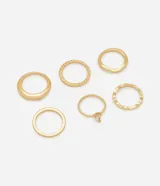 Set de seis anillos de metal en tono dorado con diversos diseños, incluyendo texturas lisas, trenzadas, onduladas y un anillo con piedra de cristal en forma de gota.
