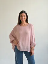 Sweater de punto en color rosado, con diseño holgado, cuello redondo y mangas murciélago anchas con vuelta.