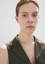 Camisa sin mangas de lino y algodón color verde militar, con cuello solapa y cierre frontal con múltiples lazos.