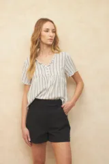 Blusa blanca con finas rayas verticales negras, de manga corta con volados y escote en V con pequeños botones y detalle de volado en el borde.