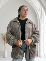 Campera marrón de tela tipo teddy con cierre frontal, cuello alto y bolsillos laterales.
