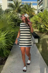 Vestido corto tejido a rayas horizontales en verde oscuro y beige, con cuello redondo y ribete celeste en el cuello y el dobladillo.