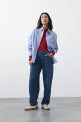 Jean de corte barrel con silueta curva y volumen controlado, de tiro medio y color negro. Presenta un diseño que se ensancha en la pierna y se ajusta levemente en el bajo, con cierre frontal y bolsillos laterales.