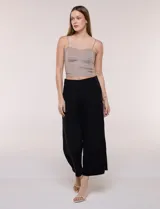 Pantalón crop de lino y rayón, con diseño wide leg de corte holgado, estampado tropical de hojas en tonos verde, azul y marrón sobre fondo blanco. Cuenta con pretina trasera elastizada y bolsillos delanteros.