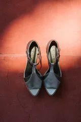 Sandalias de cuero plateadas con puntera abierta, tiras finas y tacón bajo de madera.