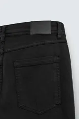 Pantalón de corte recto confeccionado en tejido de algodón con elasticidad. Presenta diseño de cinco bolsillos, cierre frontal con cremallera y botón.