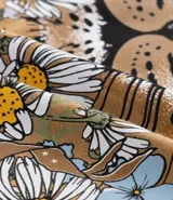 Remera alargada de algodón color ocre, con cuello redondo y mangas cortas. Presenta un estampado de la cara de un leopardo rodeada de flores y la frase "Starlit Sky".