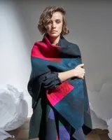 Ruana confeccionada en lana merino afieltrada, con diseño geométrico multicolor inspirado en los cultivos del campo.