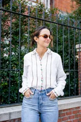 Camisa blanca de algodón con bordados de flores rosas en cuello, frente y puños, corte clásico y cierre con botones.