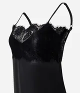 Vestido midi negro de poliuretano, con breteles finos regulables, escote en V y ruedo asimétrico adornados con encaje.