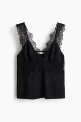 Top negro de tejido jacquard con leve brillo, escote en V y copas fruncidas. Presenta un panel transparente de encaje en el torso y ribetes de encaje decorativos en el escote y los breteles.