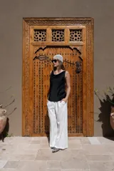 Pantalón de corte amplio y tiro alto, confeccionado en tela negra con acabado brillante y sutil efecto glitter. Presenta cintura elástica con cordón ajustable y caída fluida.