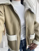 Campera color beige de ecocuero con interior de corderito blanco, cierre frontal con cremallera y bolsillos laterales.