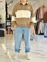 Buzo de cuello polo y medio cierre, con diseño de bloques de color en gris y blanco, de corte oversize y mangas largas.