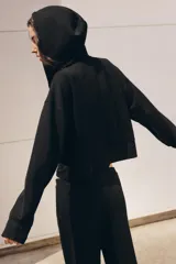 Pantalón flare de tiro medio, color azul, confeccionado en tejido de punto elástico. Cuenta con cintura elástica ajustable con cordón, bolsillos delanteros y corte amplio en las piernas.