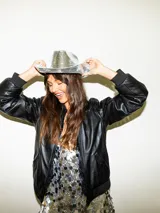 Campera bomber negra de cuero sintético con cuello, puños y ruedo acanalados.