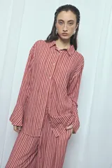 Camisa de viscosa con estampado de rayas verticales en tonos rosado y marrón, de corte oversize, con cuello camisero, cierre frontal de botones y mangas largas acampanadas.