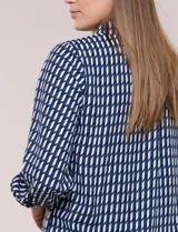 Camisa de rayón con estampado geométrico en azul y blanco, de manga larga con puños anchos abotonados y cuello camisero tradicional.
