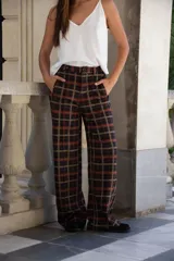 Pantalon de corte amplio y tiro alto, con diseño de cuadros en tonos oscuros, cintura con presillas y bolsillos laterales.