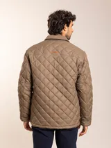 Campera acolchada azul marino con cuello de pana, cierre frontal con cremallera y bolsillos con solapa en el pecho.