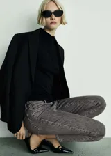 Jeans de corte slim y diseño crop, confeccionados en tejido de algodón elástico con lavado gris oscuro. Presentan tiro medio, cierre de cremallera con botón, trabillas en la cintura y diseño clásico de cinco bolsillos.