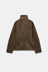 Chaqueta de gamuza sintética color marrón, con cuello subido, cierre frontal cruzado con botones y mangas largas anchas. Cuenta con bolsillos delanteros y cinturón ajustable del mismo tejido.
