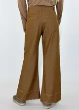 Pantalón de jean negro de corte acampanado con terminación desflecada en ruedo y cintura.