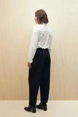 Pantalón de vestir color crema, de corte recto, con bolsillos laterales y cintura elastizada.