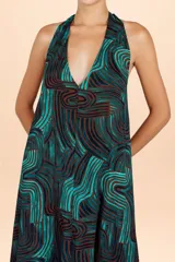 Vestido largo con escote halter y silueta de caída natural, confeccionado con un estampado de ondas orgánicas en tonos verde azulado y marrón.