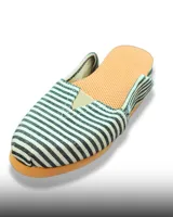 Alpargata de tela con diseño de rayas verticales en blanco y negro, con suela de goma color naranja y detalle elástico en el empeine.