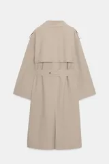 Trench largo de color negro con cuello de solapa, cierre frontal cruzado con botones y cinturón ajustable a tono. Presenta mangas largas con trabillas en los puños, bolsillos delanteros de vivo y abertura en la espalda.