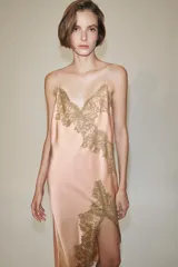 Vestido largo tipo lencero de Zara Woman Collection, confeccionado en tejido satinado color rosado con escote en pico y tirantes finos. Presenta detalles de aplicaciones de encaje a contraste y bajo asimétrico.