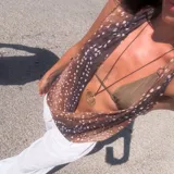 Top marrón con estampado de manchas blancas, escote en V pronunciado y tirantes finos.