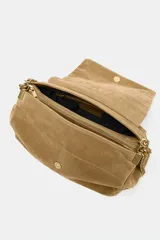 Bolso de hombro confeccionado en piel de ante color tostado, con diseño acolchado mediante pespuntes horizontales y verticales. Cuenta con una correa de cadena metálica dorada con refuerzo de piel y cierre mediante solapa con imán.