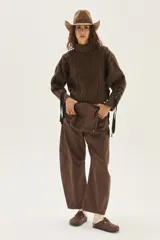 Polera de tejido de punto con diseño de ochos y detalles de tientos en contratono en las mangas. Presenta cuello alto y corte cropped.