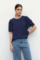 Top color verde claro, de mangas cortas abullonadas y cuello redondo.