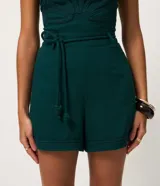 Short corto en viscolino verde oscuro, con cintura elástica, cordón ajustable con detalle de nudos y dobladillo pespuntado.