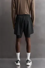 Shorts de entrenamiento azul marino con calza interior negra. Cintura elástica ajustable con cordón, bolsillos laterales con cierre y aberturas laterales en el bajo.