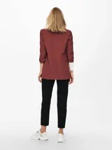 Blazer regular fit color rosado viejo, con cuello solapa, mangas 3/4 y bolsillos frontales ribeteados.