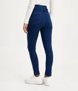Pantalón de jean azul oscuro, corte skinny, tiro alto, con trabillas en la cintura, cierre con botón y cremallera, y dos bolsillos traseros.