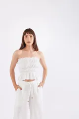Top blanco strapless con elástico fruncido en el busto y en la cintura.