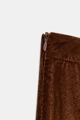 Pantalón de tiro medio confeccionado en terciopelo color marrón, con diseño bombacho, bolsillos delanteros y bajos con puño elástico. Cuenta con cierre lateral oculto.