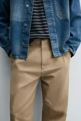 Pantalón chino de corte recto confeccionado en tejido ligero de algodón con estructura canvas. Presenta bolsillos frontales, bolsillos traseros de vivo y cierre frontal con cremallera y botón.