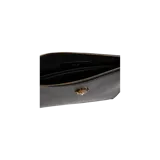 Clutch de cuero negro con cierre superior y placa metálica dorada de la cabeza de Medusa de Versace en la parte frontal.