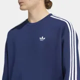 Buzo Adidas de cuello redondo con corte holgado, color azul marino. Presenta las icónicas tres rayas blancas en los hombros y mangas, y el logo del trifolio bordado en el pecho.