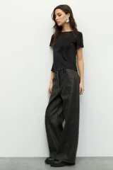 Pantalón ancho de símil cuero color negro, con grandes bolsillos laterales y traseros.